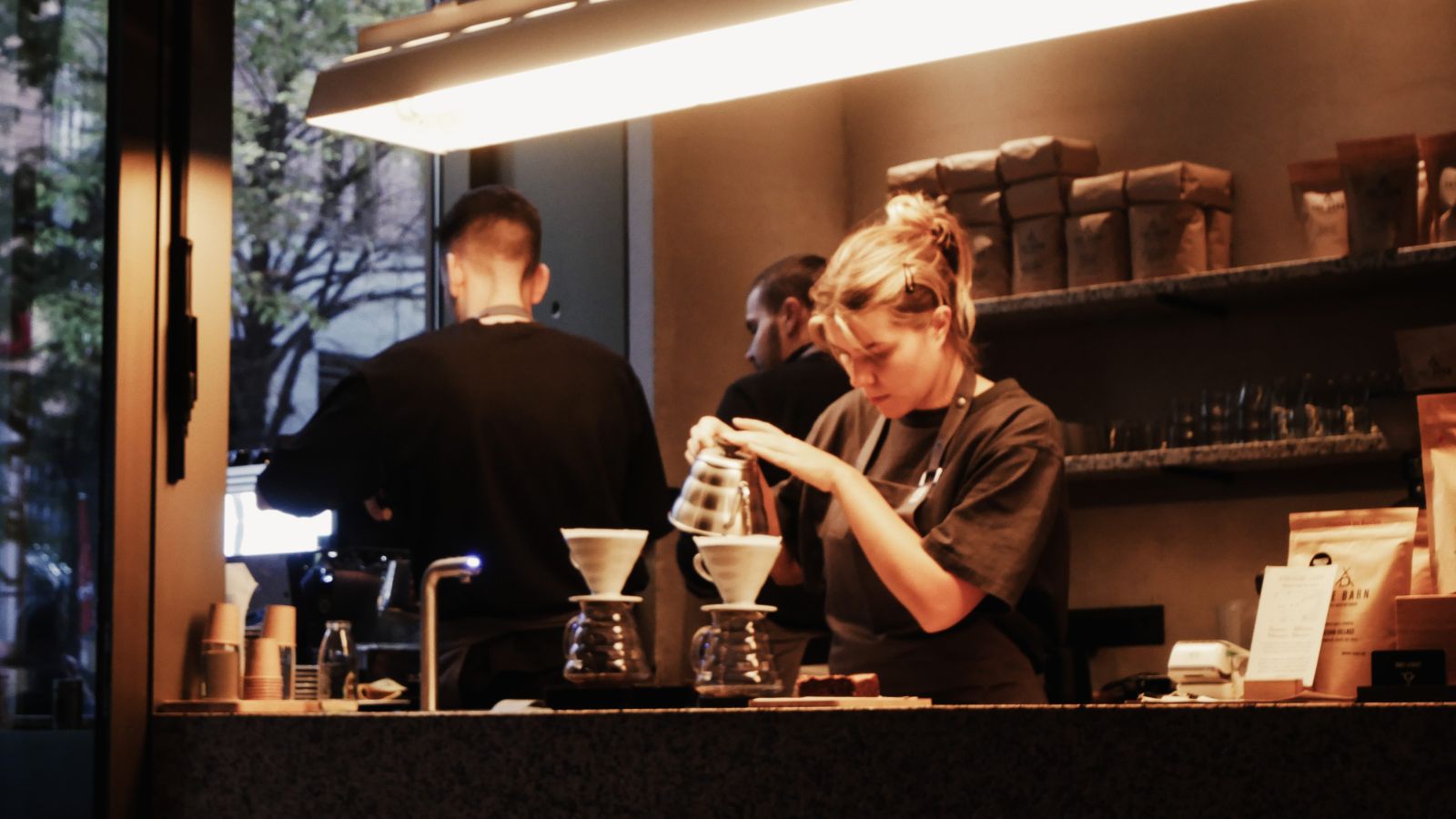 Barista versant le café dans le filtre derrière un comptoir
